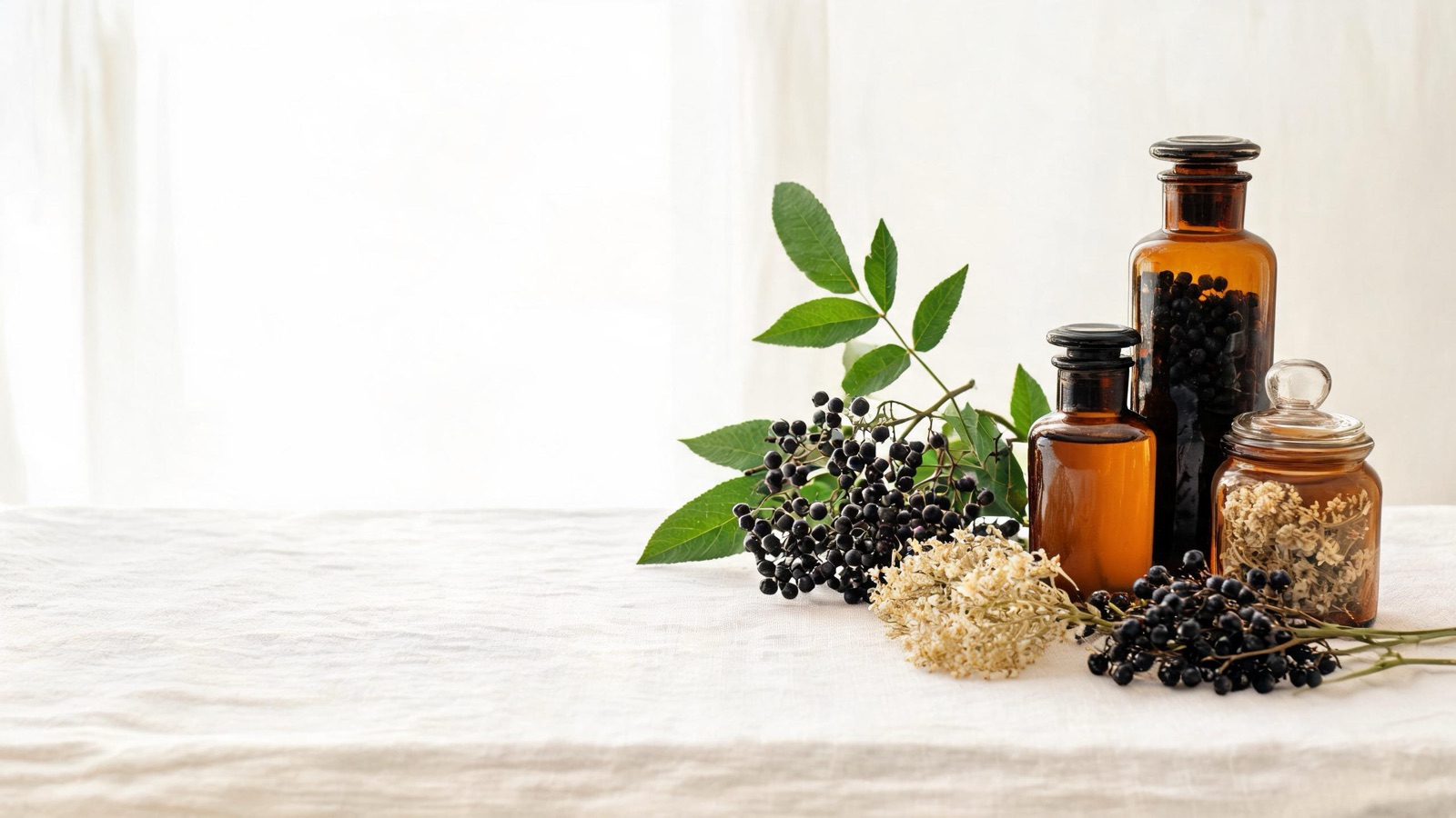 Erbe officinali, botaniche essiccate e boccette ambrate da farmacia su un piano chiaro