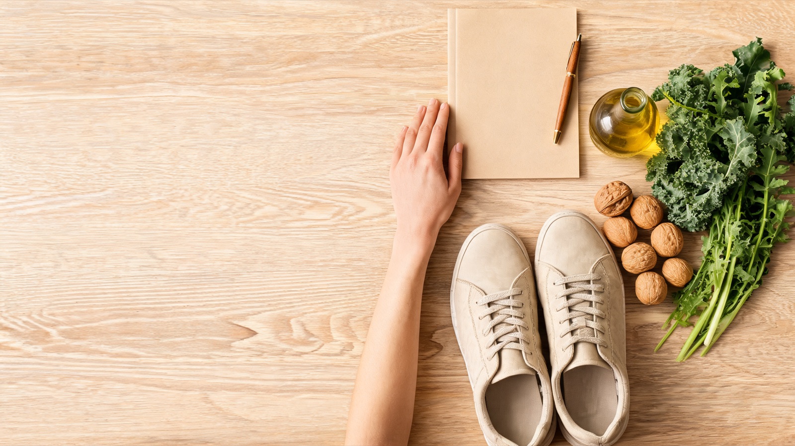Ripresa dall'alto con planner, penna, scarpe da camminata, noci, olio d'oliva e verdure a foglia